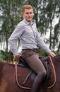 Young man riding brown horse on the countryside Royalty Free Stock Photo