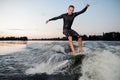 Young man riding down the river on a wake board at the evening Royalty Free Stock Photo