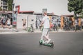 Young man riding electric scooter , escooter or e-scooter on street