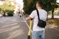 Young man riding an electric scooter on a meeting. Ecological transportation concept. Handsome man outdoors with e