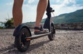 Young man riding an electric scooter on mountain range. Ecological transportation concept Royalty Free Stock Photo