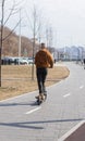 Young man riding electric scooter in urban background. Modern transport and lifestyle concept. Royalty Free Stock Photo