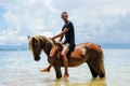 Young man riding horse on the beach on Taveuni Island, Fiji