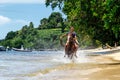 Young man riding horse on the beach on Taveuni Island, Fiji