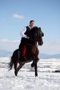 Young man riding horse outdoor in winter Royalty Free Stock Photo