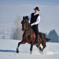 Young man riding horse outdoor in winter Royalty Free Stock Photo