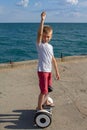 Boy riding an electric skateboard by the sea. Young man riding on the Hoverboard Royalty Free Stock Photo