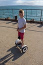 Boy riding an electric skateboard by the sea. Young man riding on the Hoverboard Royalty Free Stock Photo