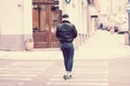 Young man riding a kick scooter on the zebra crossing