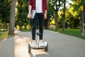 Young man riding on mini gyroboard in summer park