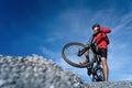 Young man riding mountain bike on the background of mountains at blue sky Royalty Free Stock Photo