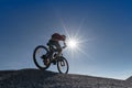 Young man riding mountain bike on the background of mountains at blue sky Royalty Free Stock Photo