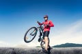 Young man riding mountain bike on the background of mountains at blue sky Royalty Free Stock Photo