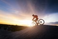 Young man riding mountain bike on the background of mountains at sunset Royalty Free Stock Photo