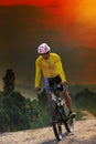 young man riding mountain bike bicycle crossing mountain hill jungle track with dusky sky scene use for out door sport and Royalty Free Stock Photo