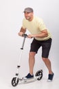 Young man riding a push scooter in studio