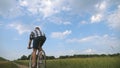 Young man riding vintage bicycle at the rural road over field. Sporty guy cycling along country trail outdoor. Male Royalty Free Stock Photo