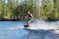 Young man riding wakeboard on summer lake Royalty Free Stock Photo