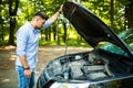 Young man on the road having problem with a car. Broken down car on the road. Traveling problem in road Royalty Free Stock Photo