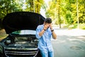 Young man on the road having problem with a car. Broken down car on the road. Traveling problem in road Royalty Free Stock Photo