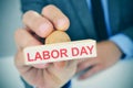 Young man with a rubber stamp with the text labor day Royalty Free Stock Photo