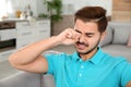 Young man rubbing eye at home Royalty Free Stock Photo