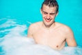 Young man rubbing eyes in swimming pool.Summer activity.Contact lens pollution, swimming in chlorine contaminated pool Royalty Free Stock Photo