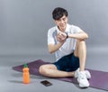 Young man runner doing stretching exercise and checking smart watch