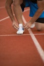 Young Man Runner tying his shoes on a running track. Shoelaces, Urban jogger Royalty Free Stock Photo