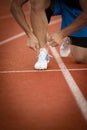 Young Man Runner tying his shoes on a running track. Shoelaces, Urban jogger Royalty Free Stock Photo