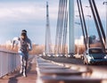 A young man running on the bridge along a river.