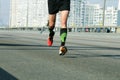 Young man running on city bridge road. Marathon running in the morning light . Running on city road. Athlete runner feet running.