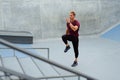 Young Man Running On Place Near Concrete Steps Outdoors. Handsome Caucasian Sportsman With Strong Muscular Body.