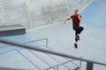 Young Man Running On Place Near Concrete Steps Outdoors. Handsome Caucasian Sportsman With Strong Muscular Body.