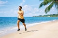 Young man running on the sea shore of tropical beach Royalty Free Stock Photo