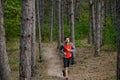Young Man Running on the Trail in the Wild Pine Forest. Active Lifestyle Royalty Free Stock Photo