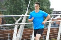 Young Man Running In Urban Setting Listening To Music