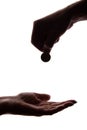 Young man`s hand with a coin gives alms - silhouette, help