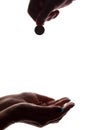 Young man`s hand with a coin gives alms - silhouette, help