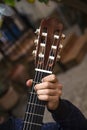 Young man`s hand playing strings of a spanish guitar