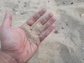 Young man's hands are picking up and playing with sand on the beach Royalty Free Stock Photo