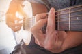 Young man`s hands playing acoustic guitar.The guitar is a fretted musical instrument that usually has six strings.Practicing in