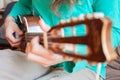 Young man`s hands playing an acoustic guitar ukulele at the home. A man playing ukulele in close up view Royalty Free Stock Photo