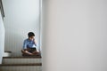 Young man sad and desperate while sitting on staircase.