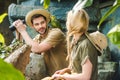 young man in safari suit with parrot on shoulder flirting with woman while hiking