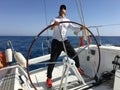 Young man sailing yacht steering wheel vacation sail Royalty Free Stock Photo