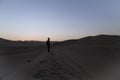 young man on sand in a desert near Huacachina, Ica region, Peru. The sunset desert view Royalty Free Stock Photo