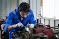 Young man sanding or iron at industrial factory, mechanic working job while polish metal.