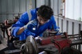 Young man sanding or iron at industrial factory, mechanic working job while polish metal.