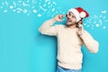 Young man in Santa hat listening to Christmas music Royalty Free Stock Photo